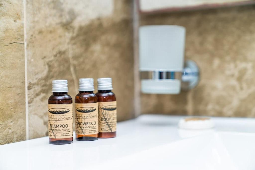 two bottles of honey sitting on a counter in a bathroom at Stylish Apt In Alliance Palace in Batumi