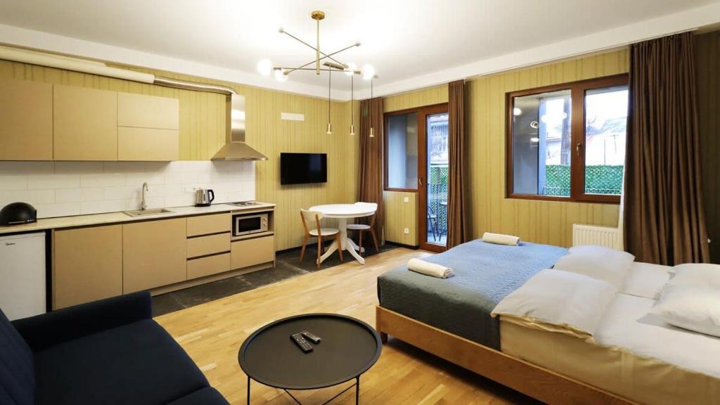 Un dormitorio con una cama y una cocina y un sofá. en Comfortable Studio In Tbilisi, en Tiflis