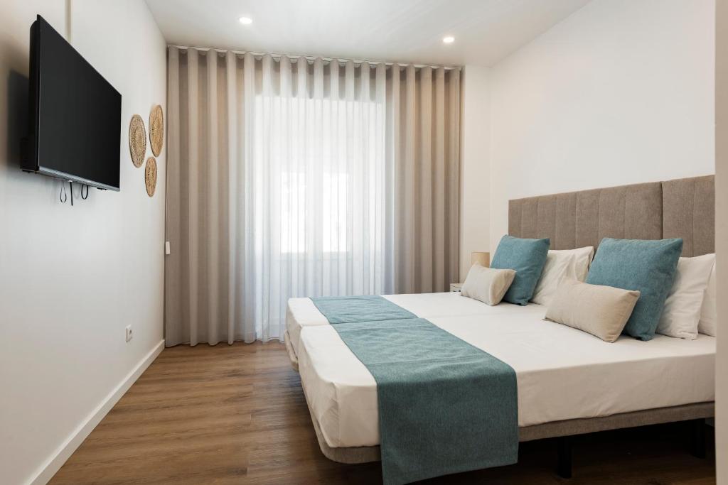 Postel nebo postele na pokoji v ubytování Madalena Hostel e Suites