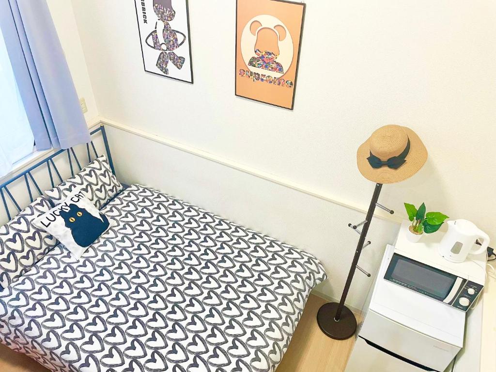 a bedroom with a bed and a hat on a table at A02 Shinjuku center-4mins to room 10min to Kabukicho-新宿商圈Loftoom in Tokyo