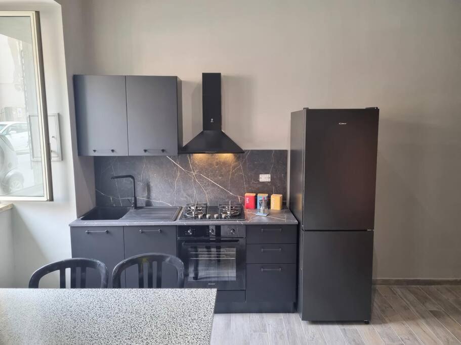 cocina con nevera negra y fogones en L'altra Vinedda - Proppro SRL - Milazzo, en Milazzo