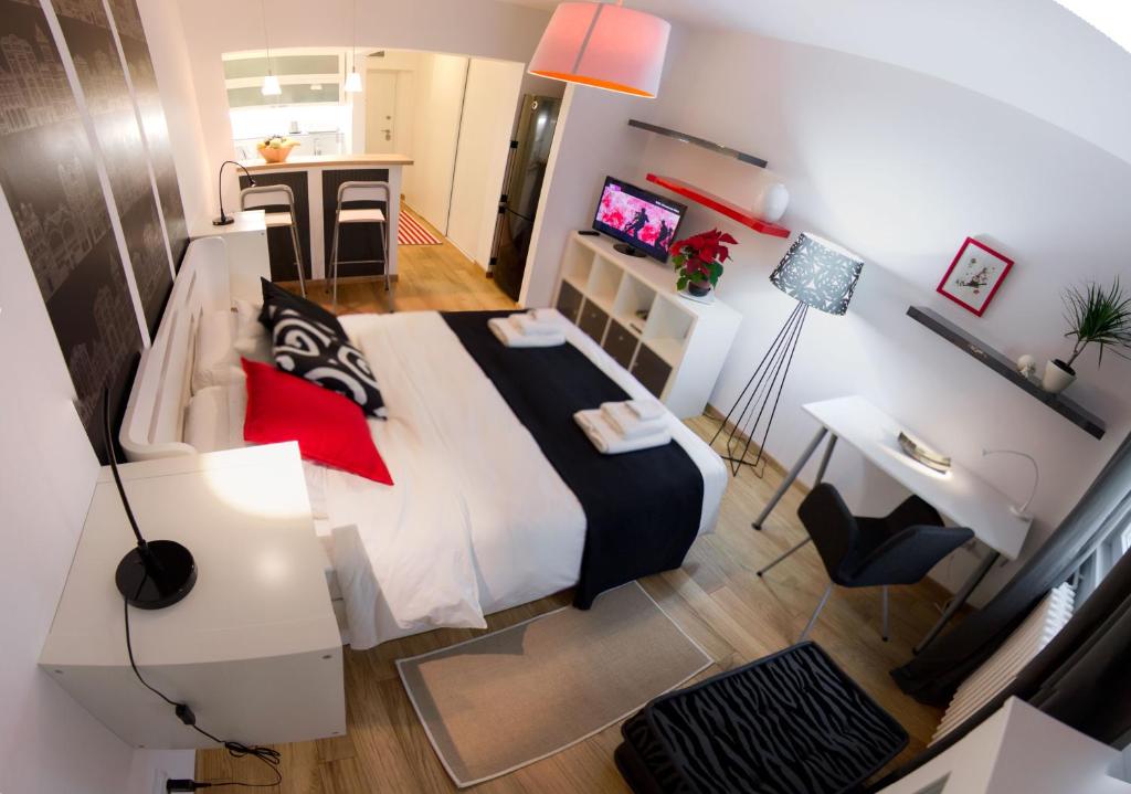 a bedroom with a large bed with red pillows at Apartment Madera in Belgrade