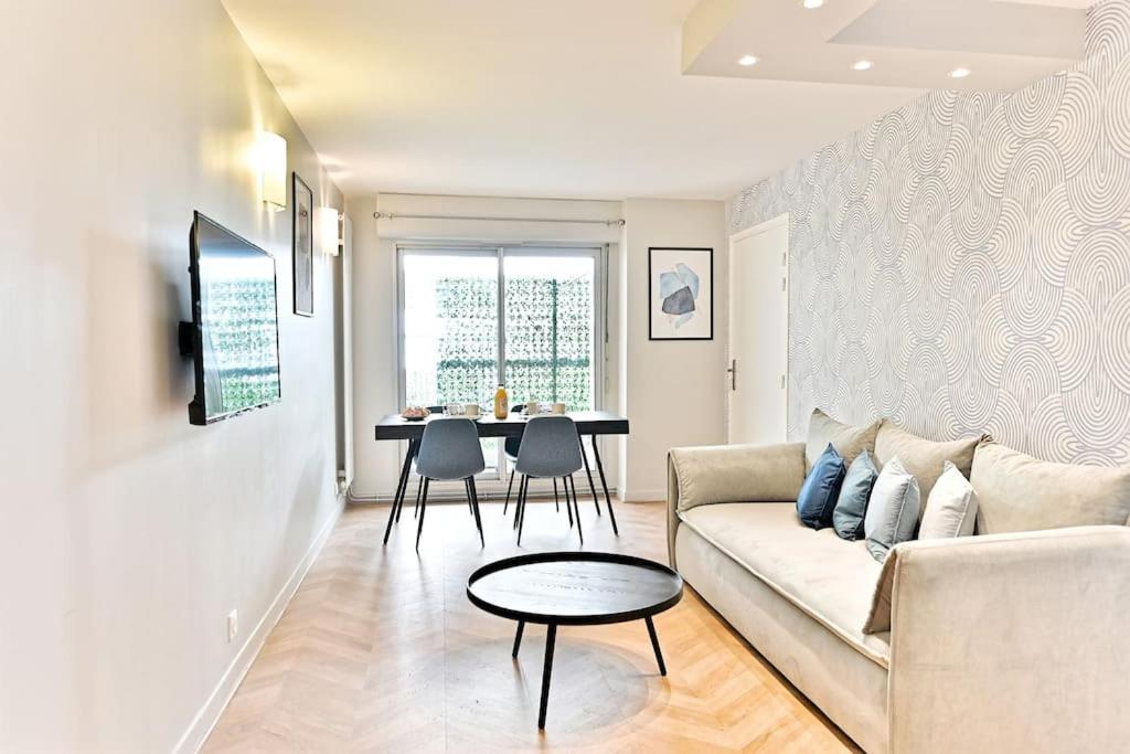 un salon avec un canapé et une table dans l'établissement Appartement spacieux et paisible Paris 19ème, à Paris