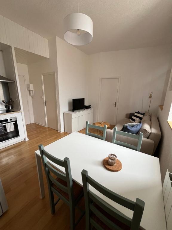 une cuisine et un salon avec une table et des chaises dans l'établissement Appartement en centre ville, à Hendaye