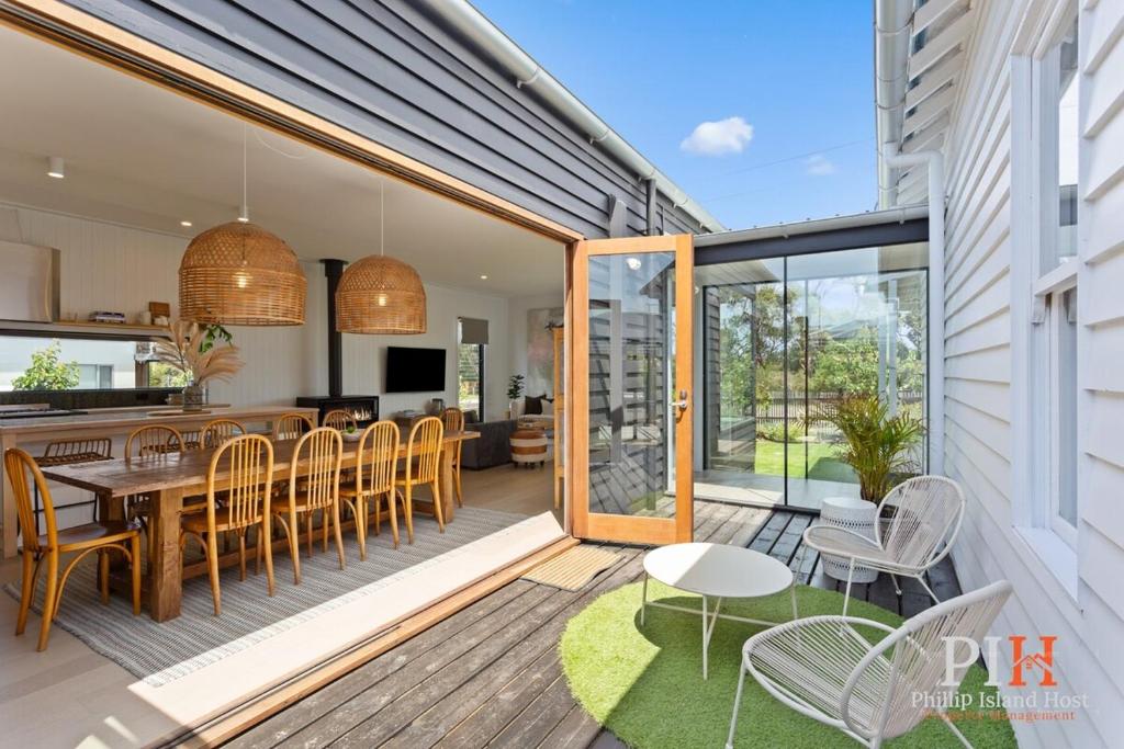 a patio with a table and chairs on a deck at Charming 4 BR Cottage Retreat in Newhaven