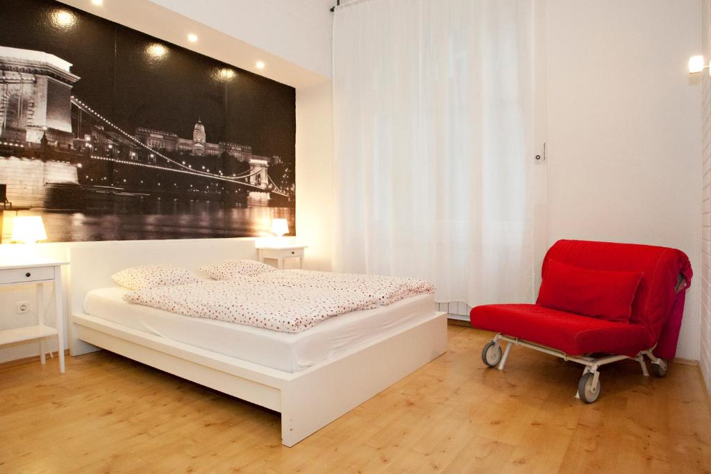 a bedroom with a bed and a red chair at Diana Apartment On Váci Utca in Budapest