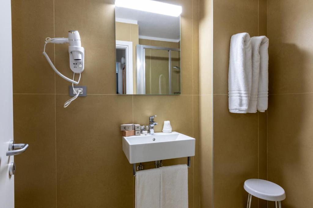un bagno con lavandino e specchio di Appartamenti Corte Residence a Borca di Cadore
