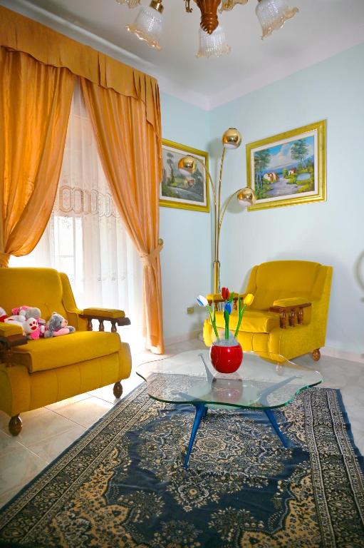 a living room with two yellow couches and a table at Giardino Darianna in Ripacandida