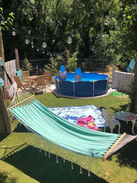 a hammock in a yard with a blue tub at Apartamento Guadalvivir in Mogón