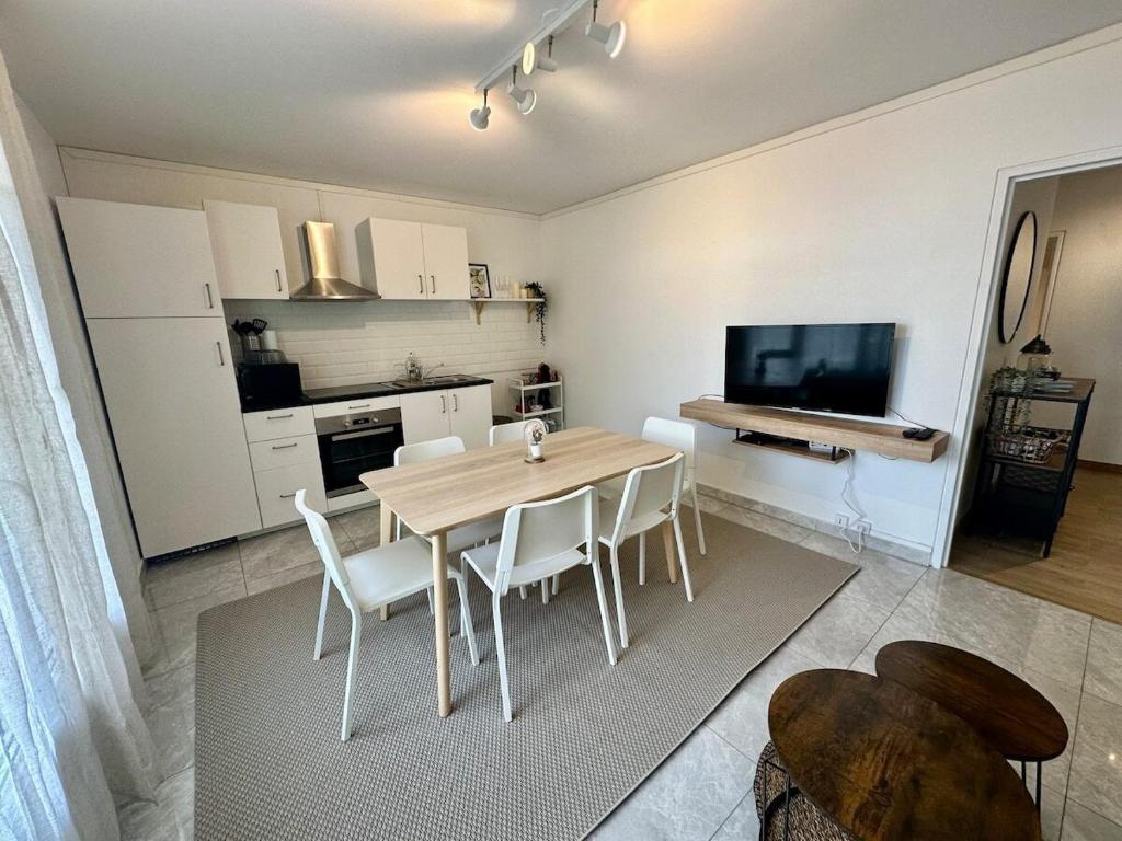 une cuisine et une salle à manger avec une table et des chaises dans l'établissement Au Coeur du Quartier Taittinger, à Reims