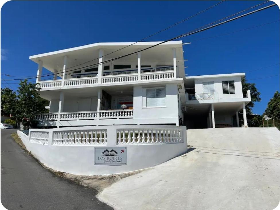 a large white house with a large balcony at Los Roires Beach Apartments in Fajardo