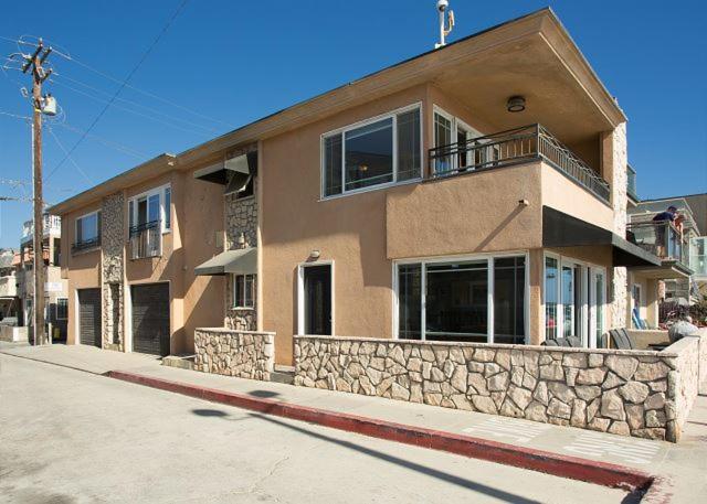 a building on a street with a stone wall at 2314 W Oceanfront A & B in Newport Beach