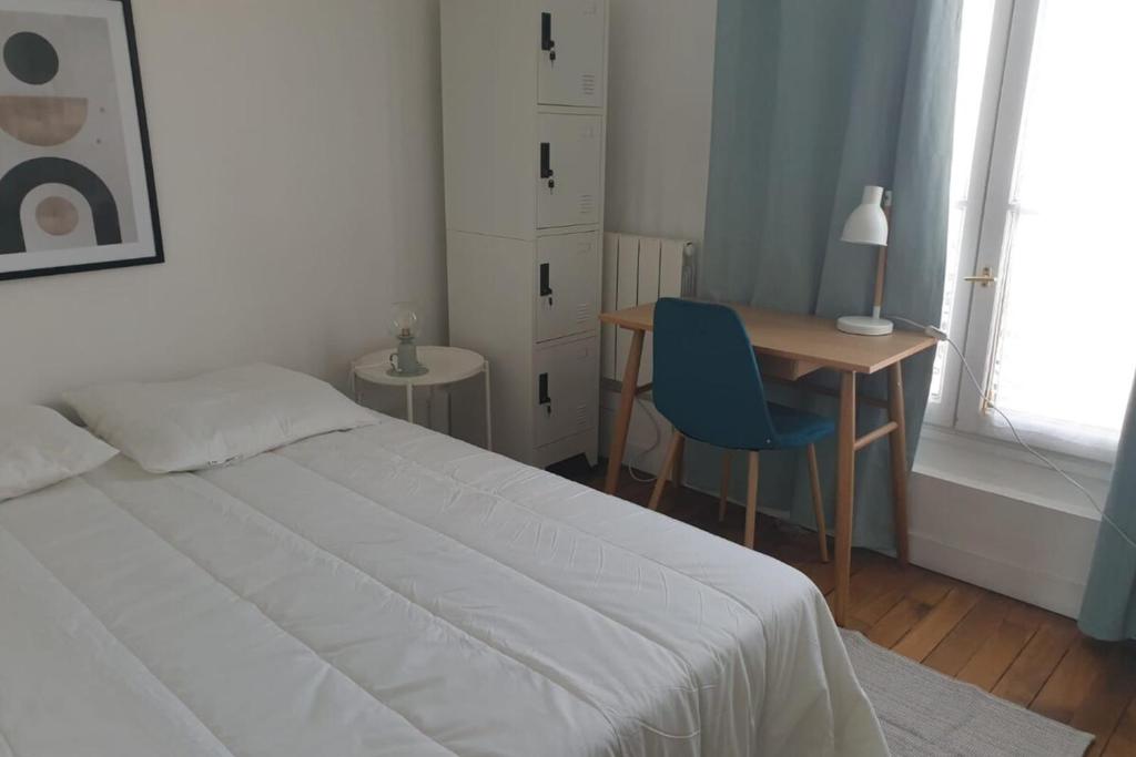 une chambre avec un lit, un bureau et une table dans l'établissement Flexliving - room - Voltaire, à Paris