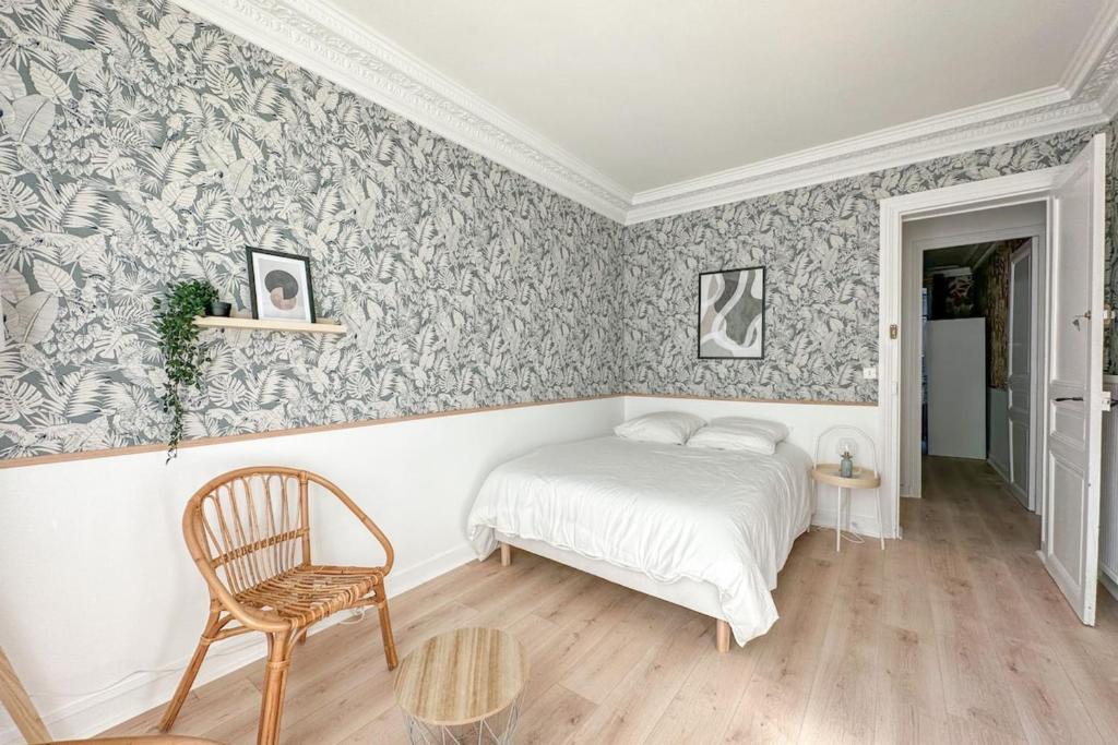 une chambre avec un lit et une chaise dans l'établissement Flexliving - room - Jura, à Paris