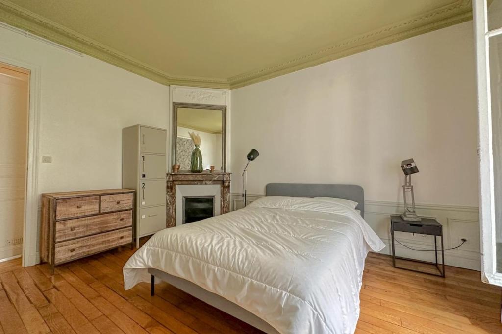une chambre avec un lit, une commode et un miroir dans l'établissement Flexliving - room - Bachaumont, à Paris