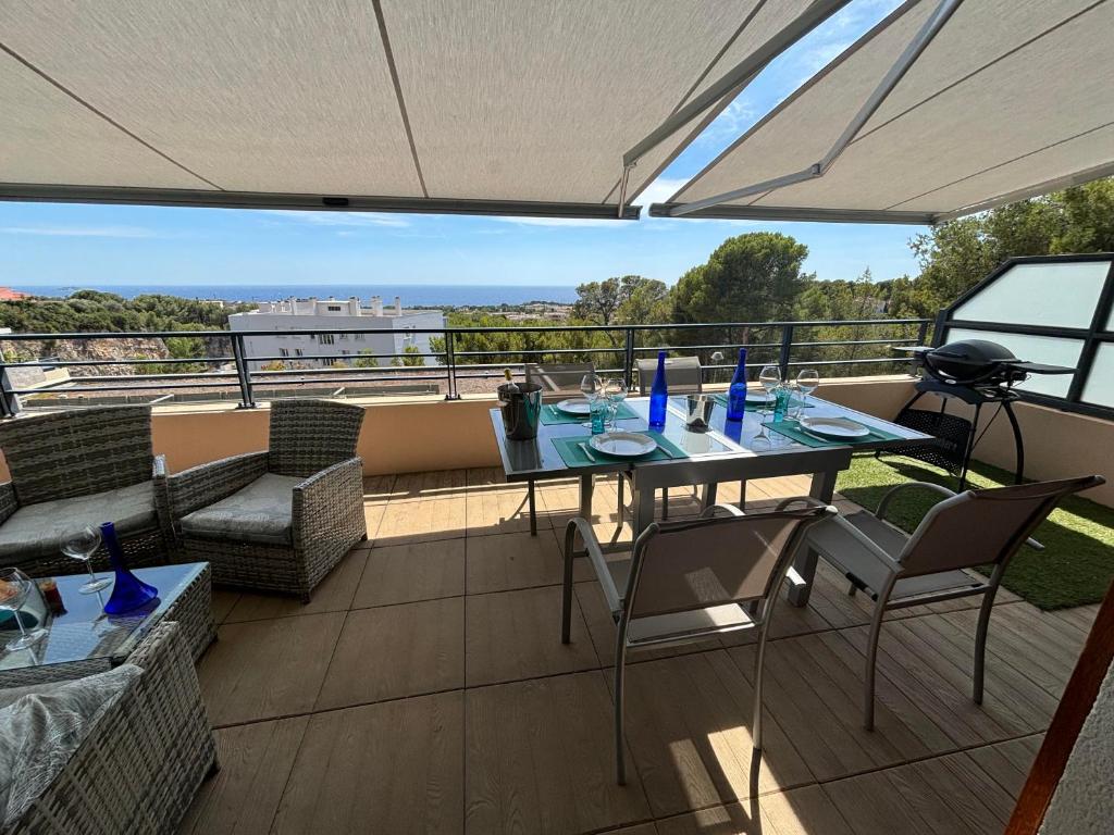 un patio avec une table et des chaises sur un balcon dans l'établissement BANDOL Magnifique appartement Vue mer Résidence Blue Bay, à Bandol