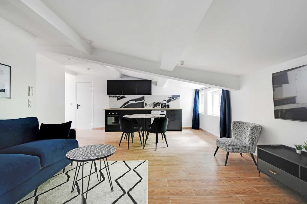 un salon avec un canapé bleu et une table dans l'établissement Refreshing 2BD-6P apartment - 18th ard, à Paris