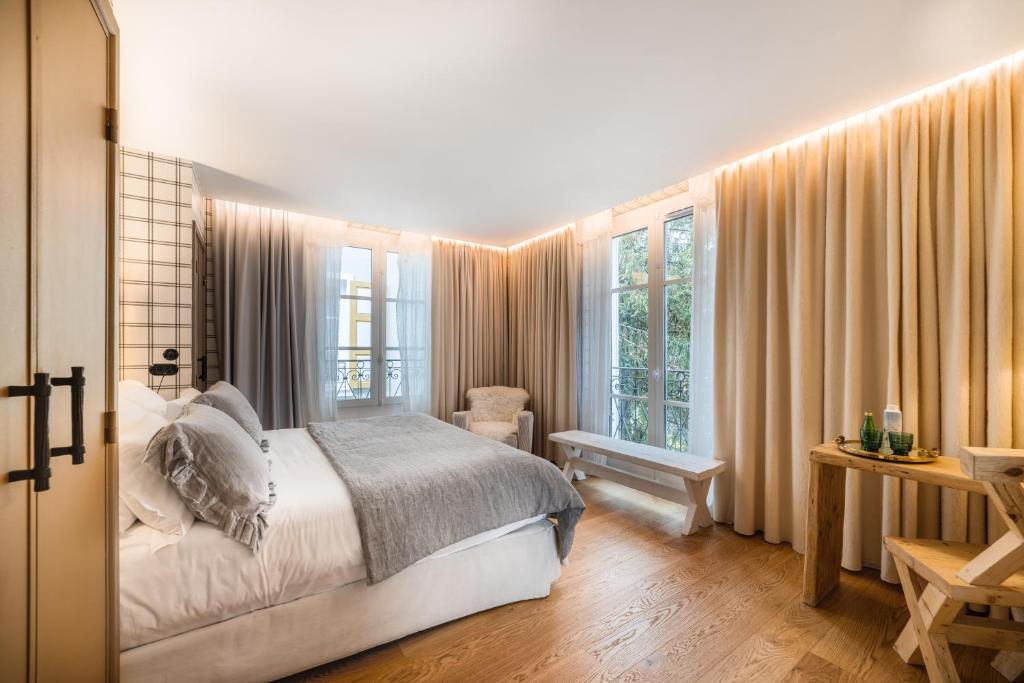 a bedroom with a bed and some windows at Grand Hotel Soleil d'Or in Megève