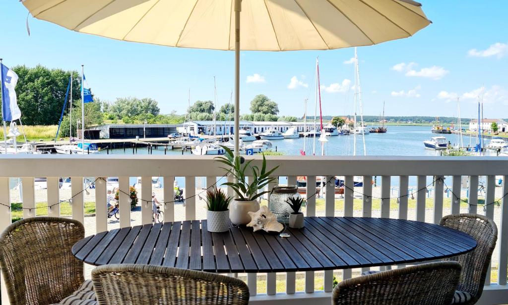 a table on a balcony with a view of a marina at Hafenidyll 46 - exklusiv am Yachthafen mit zwei Bädern - traumhafte Sonnenuntergänge inklusive in Karlshagen