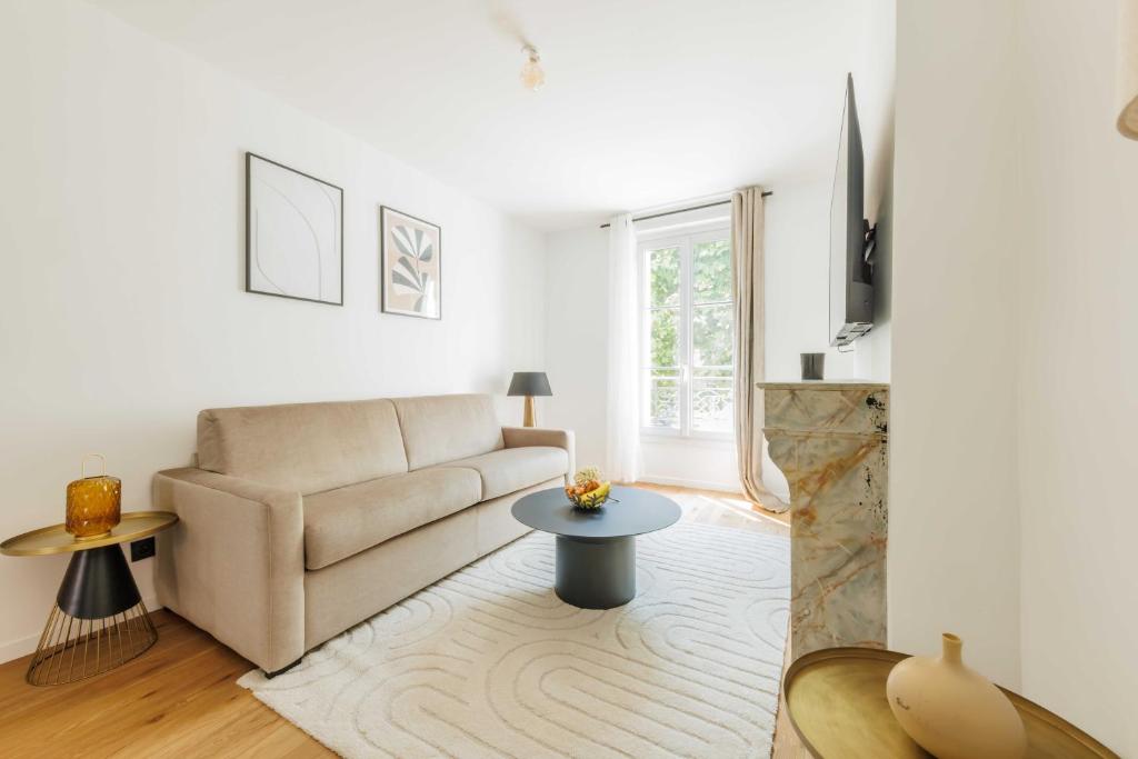 un salon avec un canapé et une table dans l'établissement Chic appartement - 1BR-4P - Château de Vincennes, à Vincennes