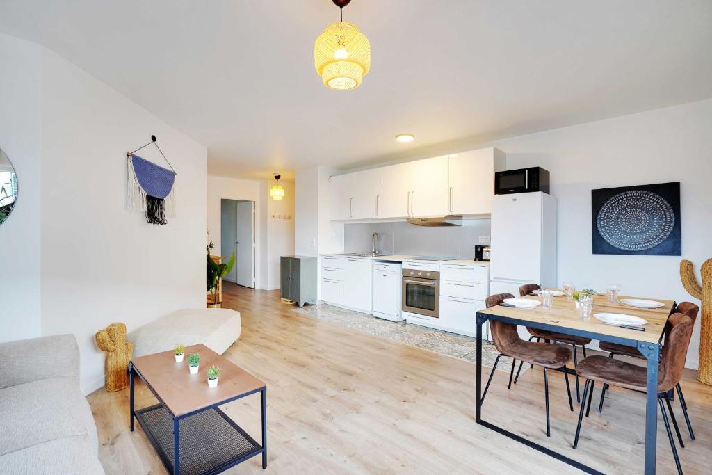 un salon avec une table et une cuisine dans l'établissement Sumptuous 3BR-6P Apartment with terrace-Near Paris, à Saint-Ouen