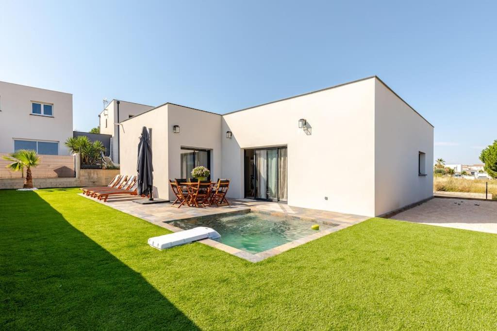 une cour arrière avec une piscine et une maison dans l'établissement Villa Tobias - Piscine & Pétanque - Proche plages, à Sérignan