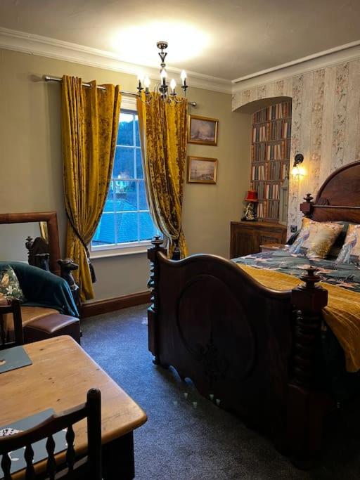 a bedroom with a bed and a table and a window at Jubilee View, Studio Apartment in Matlock Bath in Matlock Bank