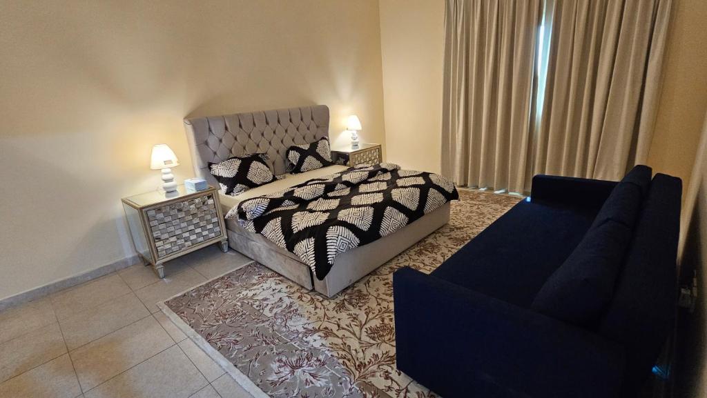 Un dormitorio con una cama, un sofá y una silla. en Splendid Private Rooms, en Sharjah