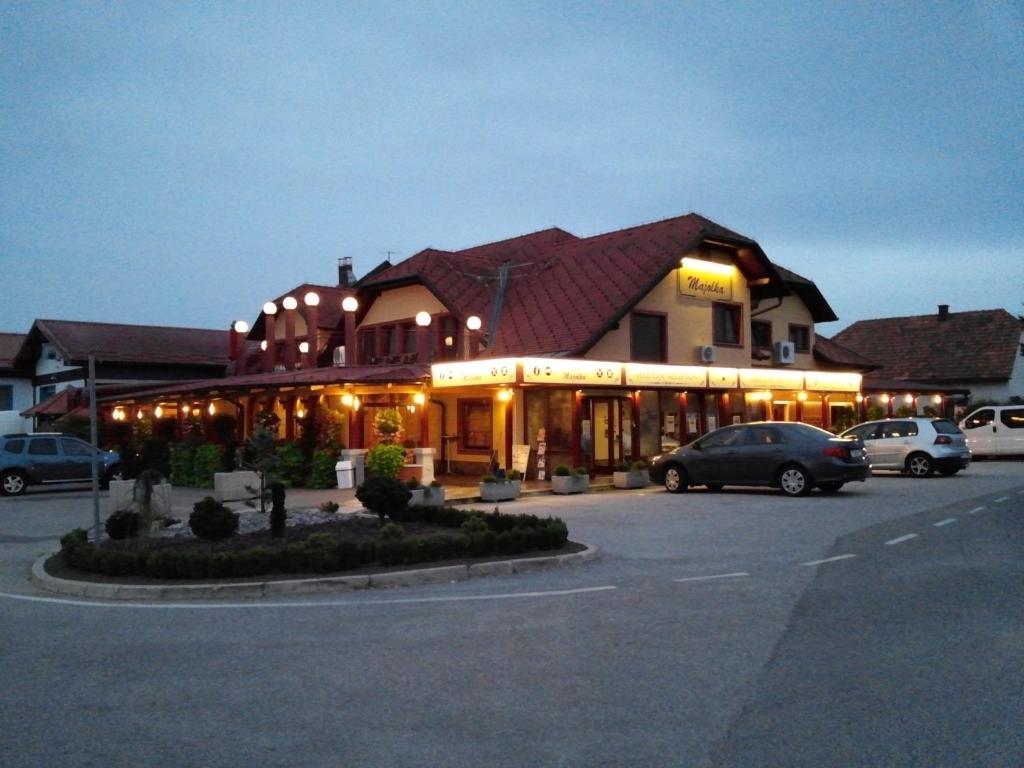 ein großes Gebäude mit Autos auf einem Parkplatz in der Unterkunft Motel Majolka in Ptuj