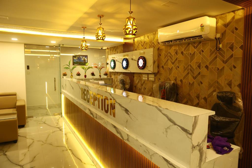 un vestíbulo con un mostrador con relojes en la pared en Grand Tamim Hotel, en Mangalore