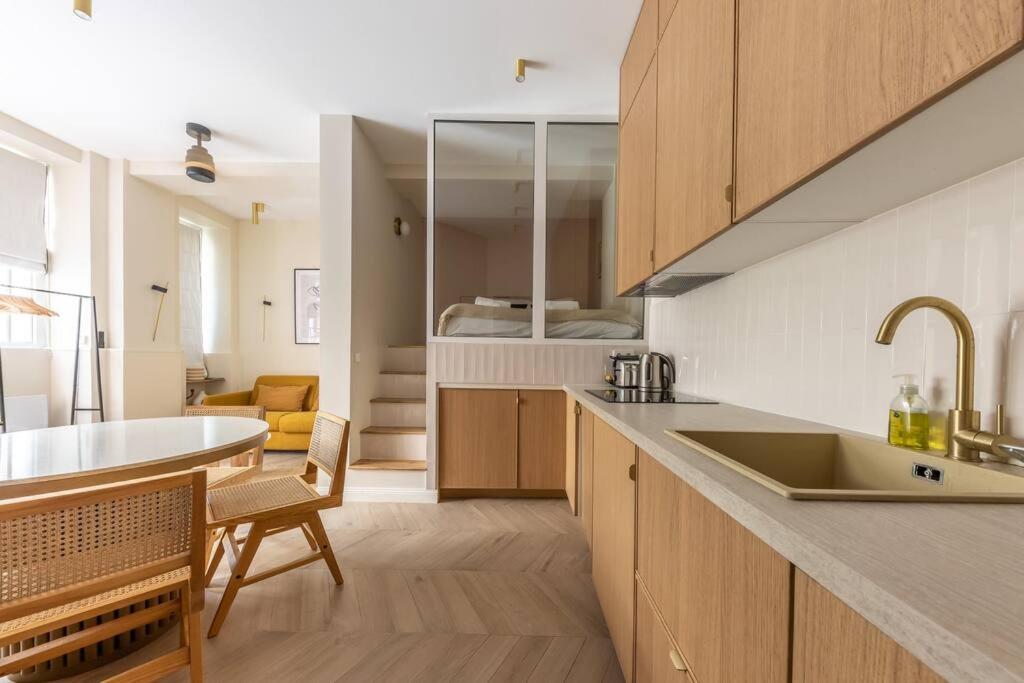 - une cuisine avec un évier et une table dans une chambre dans l'établissement Elegant 4-Star stay in central Paris - Suite Apart, à Paris