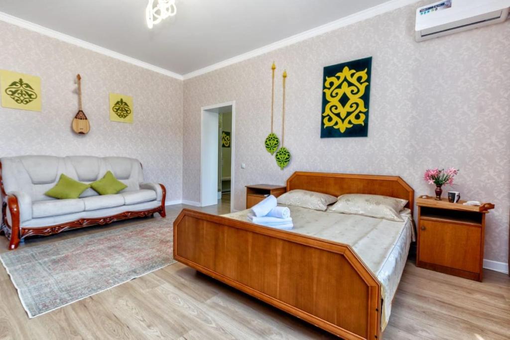 a bedroom with a large bed and a couch at Венский квартал in Prigorodnyy
