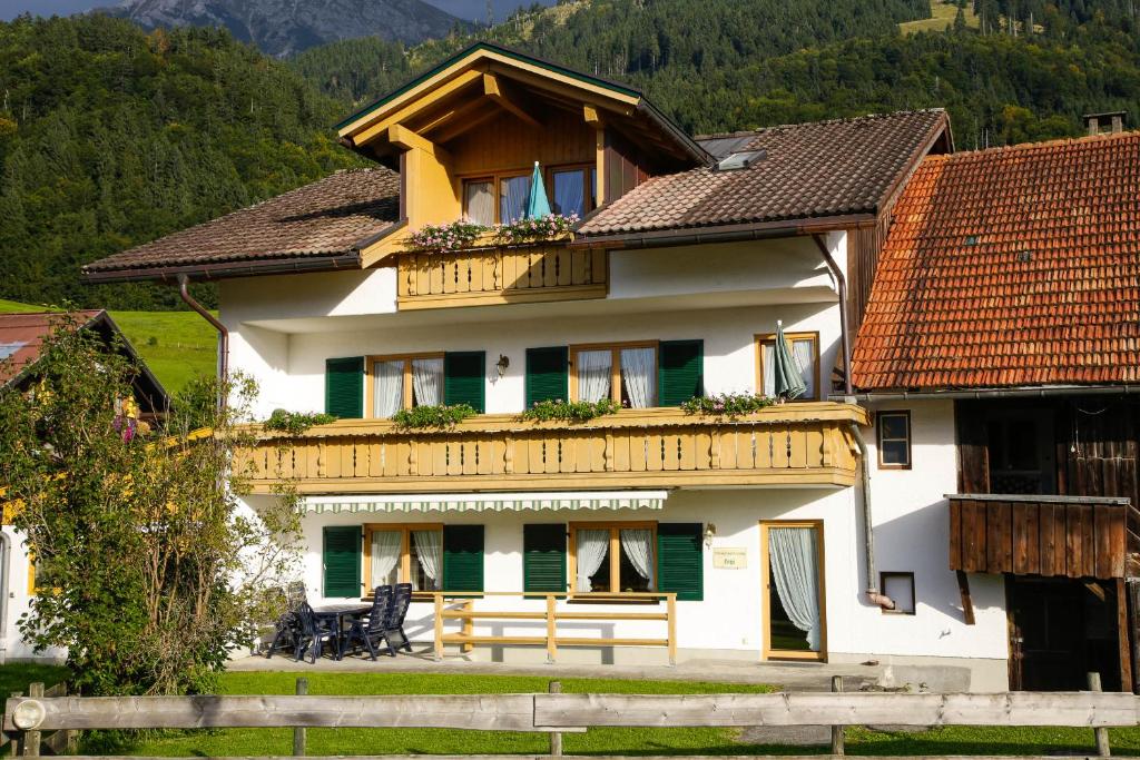 ein großes weißes Haus mit Holzdach in der Unterkunft "Ferienwohnung Anna" - Annehmlichkeiten von 4-Sterne Familien-und Wellnesshotel Viktoria können mitgenutzt werden in Oberstdorf