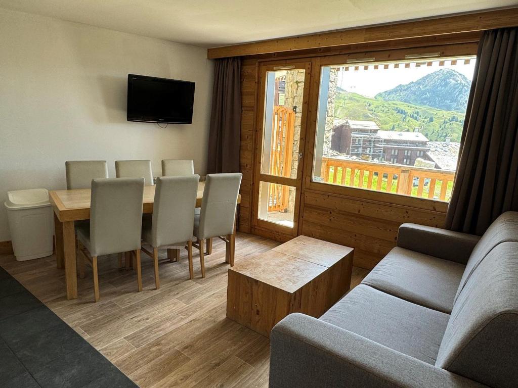un salon avec une table, des chaises et un canapé dans l'établissement Appartement skis aux pieds, 6 pers, piscine, bien-être, Belle Plagne - FR-1-181-2810, à La Plagne Tarentaise