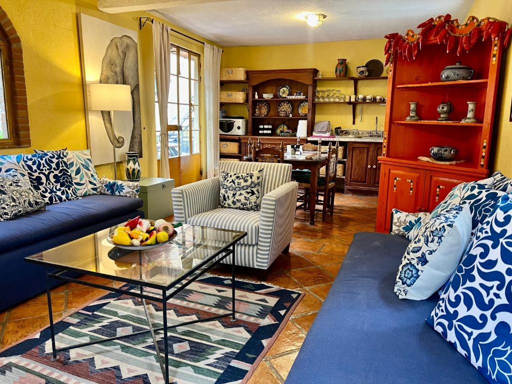 a living room with a blue couch and a glass table at Boutique Hotel Casa Camellia in San Miguel de Allende
