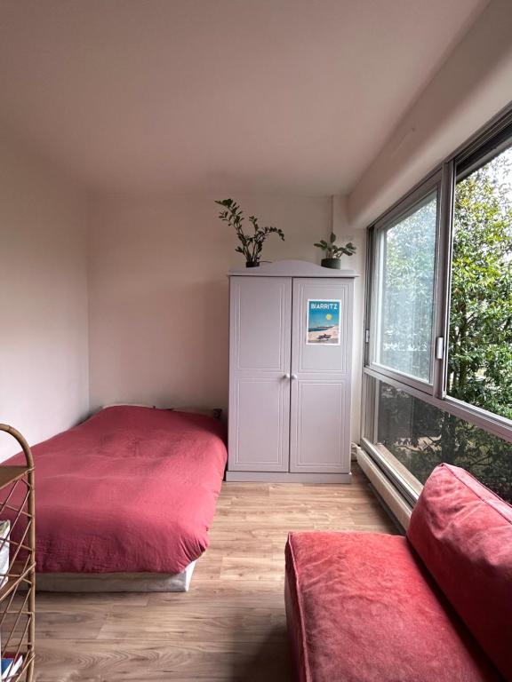 ein Schlafzimmer mit einem Bett, einem Schrank und einem Fenster in der Unterkunft Charmant appartement vue jardin in Neuilly-sur-Seine