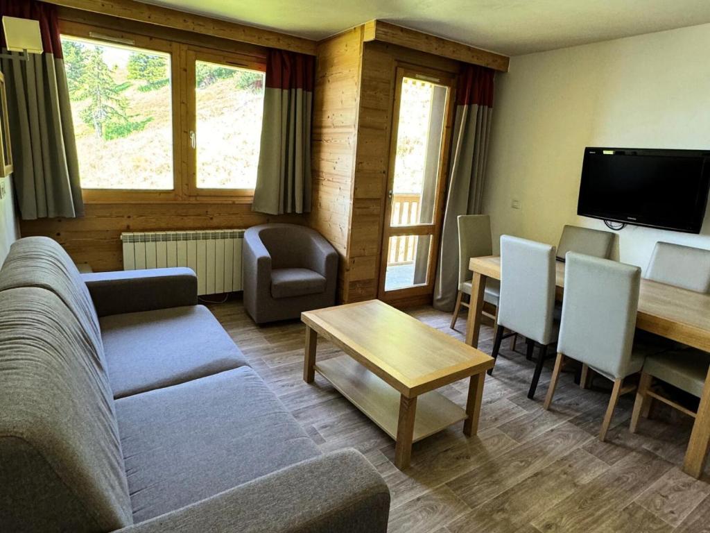 un salon avec un canapé et une table dans l'établissement Résidence Le Centaure - 2 Pièces pour 6 Personnes 601, à Aime La Plagne