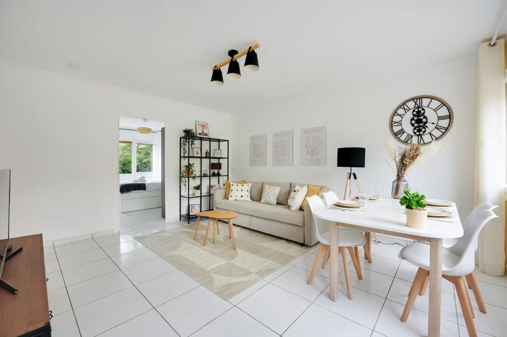 un salon blanc avec un canapé et une table dans l'établissement Le Matisse - 6 p - Entre Paris & Disney - Métro 8, à Maisons-Alfort