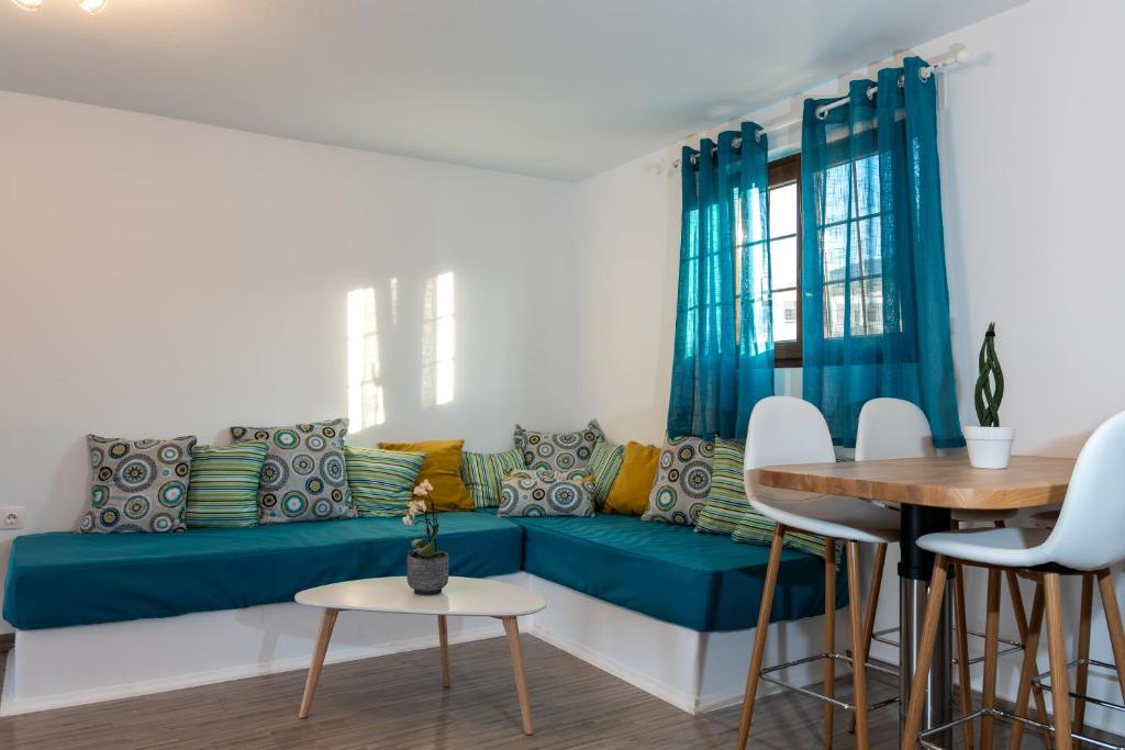 a living room with a blue couch and a table at Allegro seasight appartment in Livadi Astypalaias