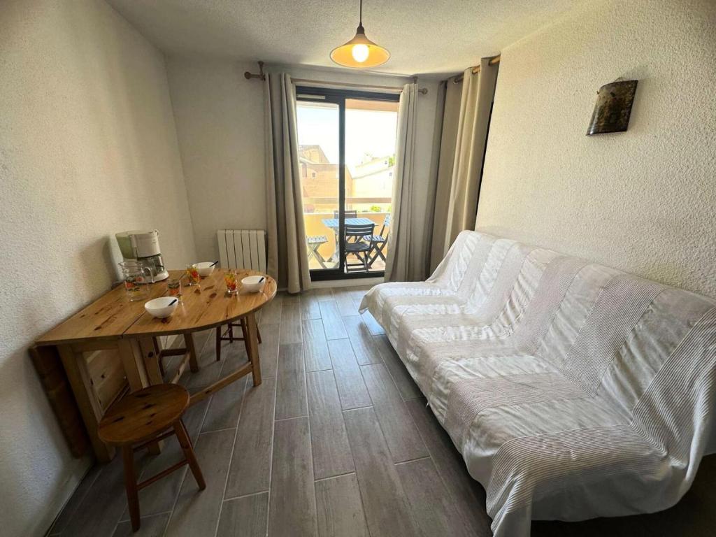 un salon avec un canapé et une table dans l'établissement Résidence Cap Vert - Coquet T2 front de mer dans domaine avec piscine et tennis MAE-5634, à Six-Fours-les-Plages