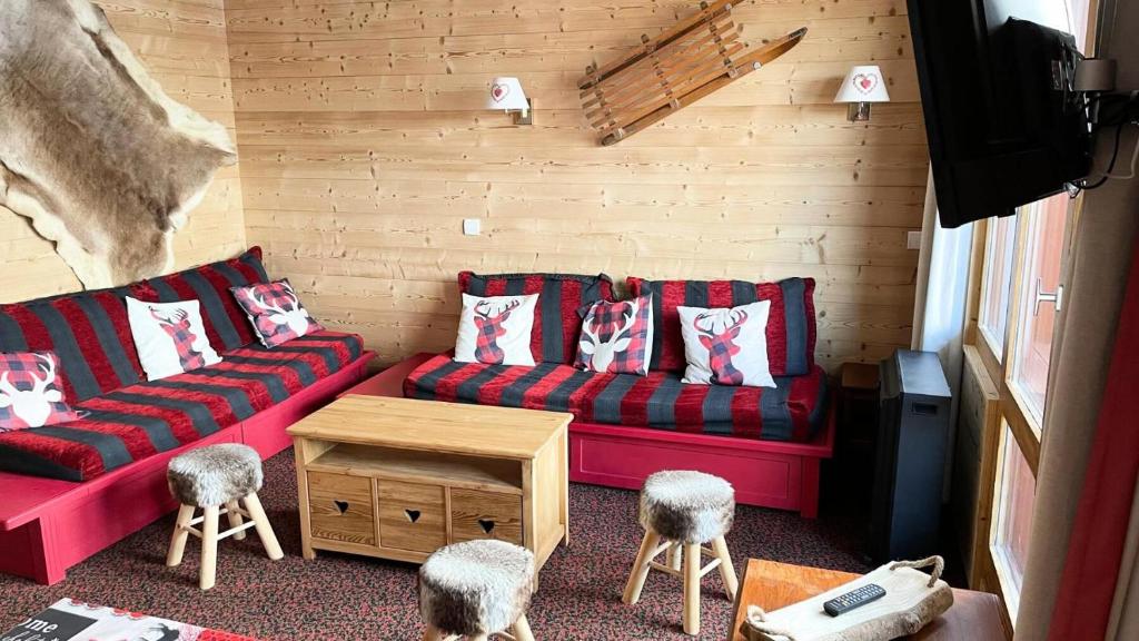 - un salon avec un canapé rouge et des tabourets dans l'établissement Résidence Le Mont Soleil A - 3 PIECES 6 pers balcon sud, sur pistes - PLAGNE SOLEIL MAE-9404, à Aime La Plagne