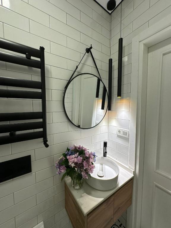 a bathroom with a sink and a mirror at Home Side Apartment in Batumi