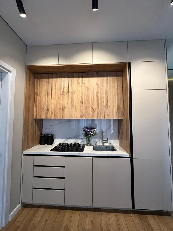 a kitchen with white cabinets and a sink at Home Side Apartment in Batumi