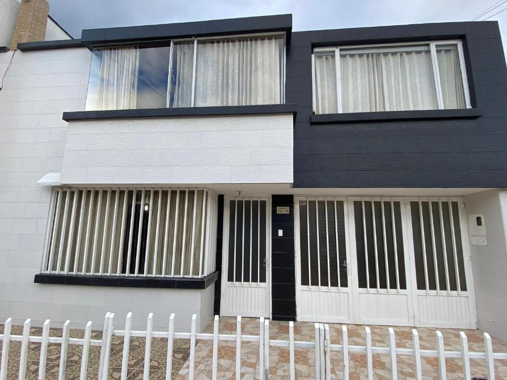 una casa nera con porte bianche e una recinzione di Casa en Paipa, Boyacá a Paipa