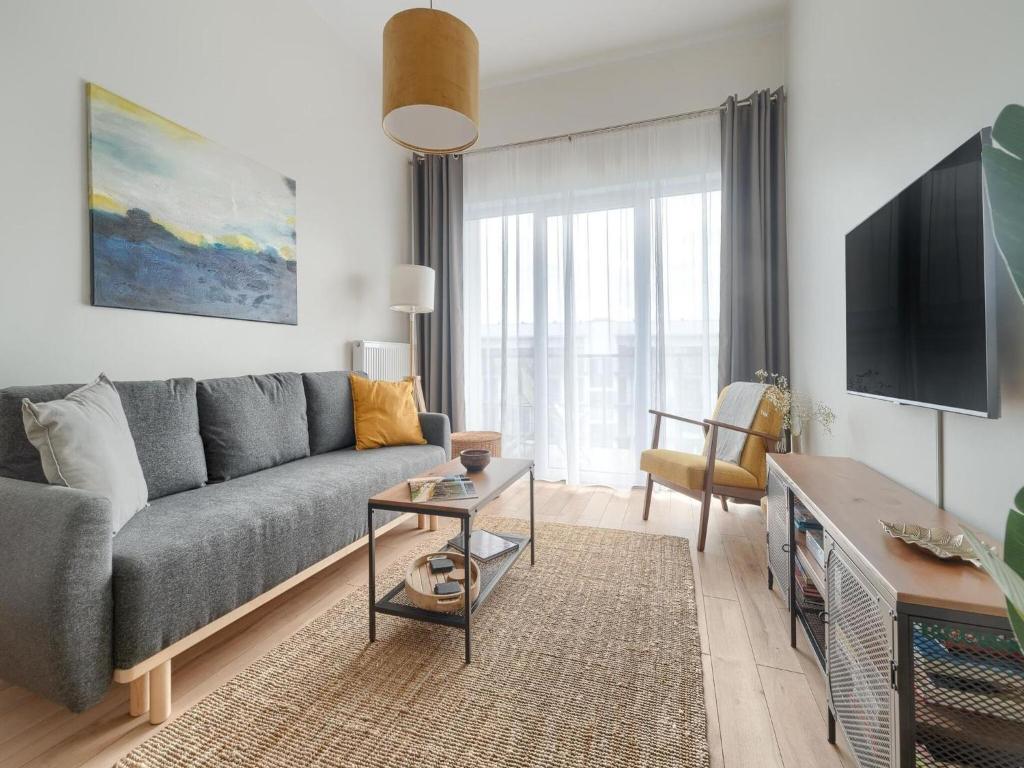 un salon avec un canapé et une télévision dans l'établissement Apartment in Dziwnów near sandy beach, à Dziwnów
