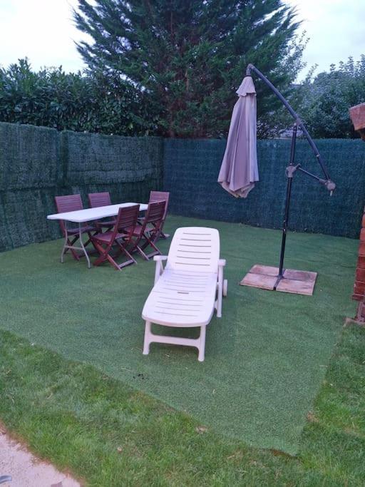 un patio avec une table, un parasol et des chaises dans l'établissement Logement proche Paris et Orly, à Limeil-Brévannes