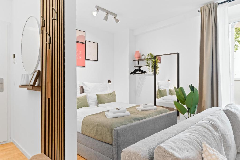 Un dormitorio blanco con una cama y un espejo. en WHONAP - PINK LION I Parkplatz I Zentral I Terrasse I Küche I Business, en Neckarsulm
