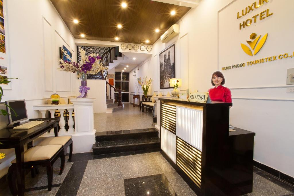 a woman standing at a counter in a salon at Hanoi Luxury Hotel in Hanoi