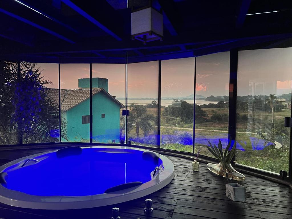 a large blue tub in a room with a large window at Ibiraquera Life in Praia do Rosa