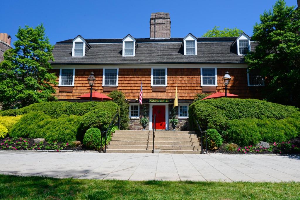 een groot bakstenen huis met een rode deur bij Nassau Inn in Princeton